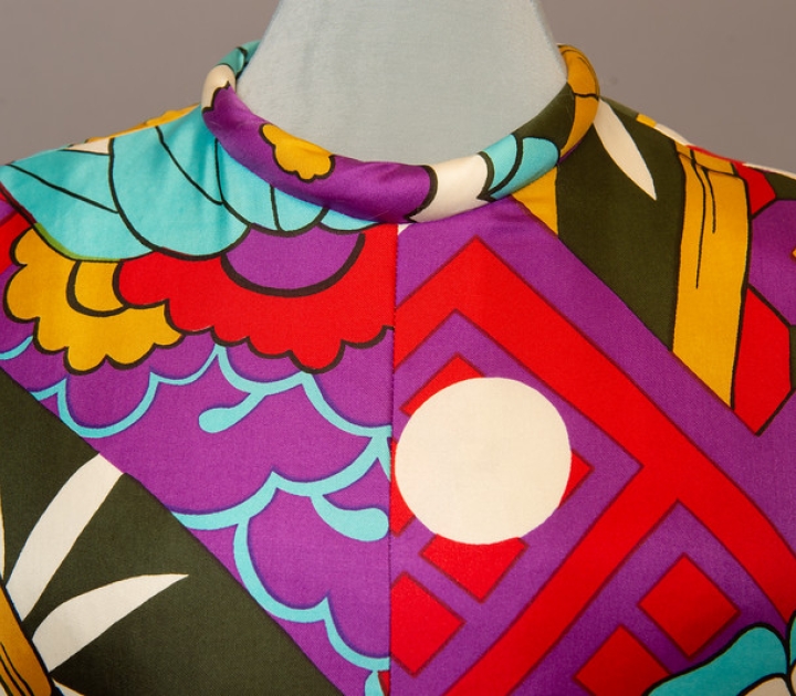 Detail of colorful 1960 print dress in reds, blues, and purples