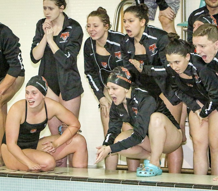 Members of women's swim team cheering on a teammate