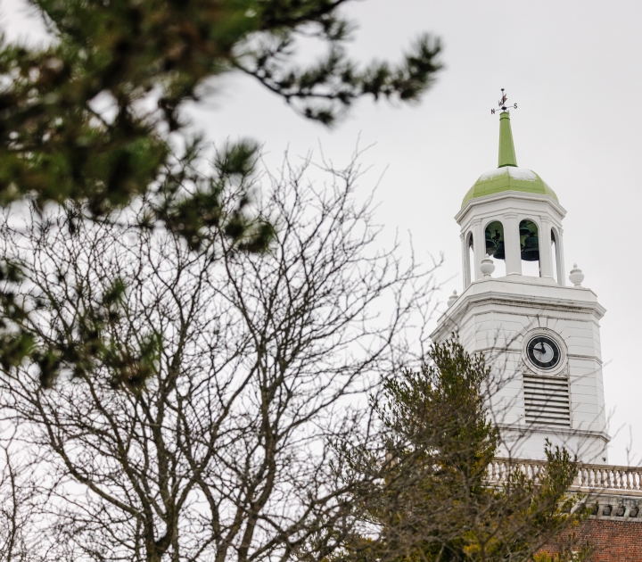 A view of the Rockwell Hall clocktower with a tree in front