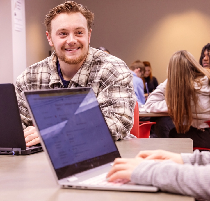 Student in business class with laptop