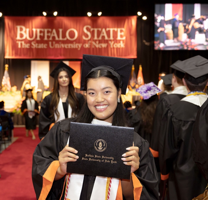 Commencement student holding a diploma