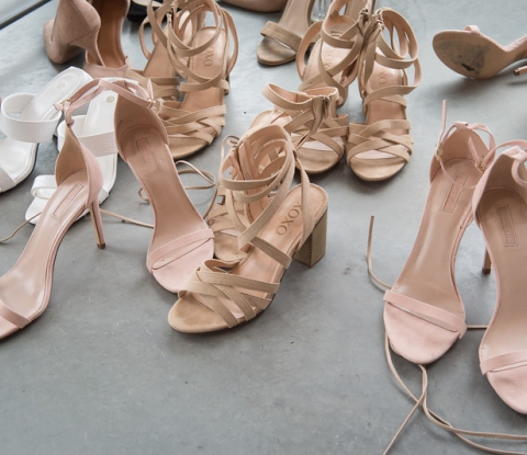 A collection of pink high-heel shoes on the floor