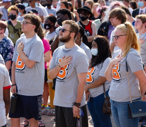 Students in Buffalo State T-Shirts standing with hands over hearts taking the Oath of Matriculation