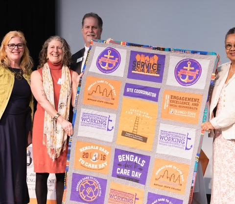 Laura Hill Rao, Joy Guarino, James Mayrose, and Kate Conway-Turner pose with special quilt made of Dare to Care T-shirts