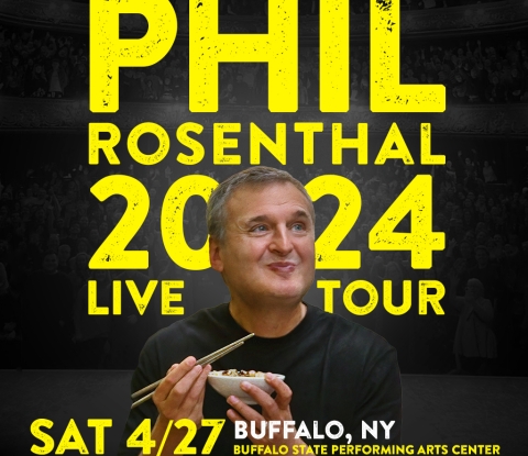 Phil Rosenthal smiling and eating with chopsticks