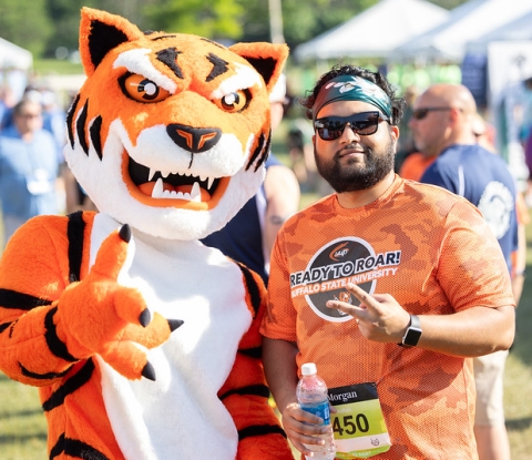 Benji the Bengal and a Buffalo State participant give the Victory sign at the Corporate Challenge