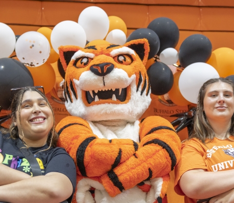 Two female students pose with Benji the Bengal mascot