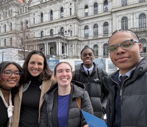 Five college students in front of a building