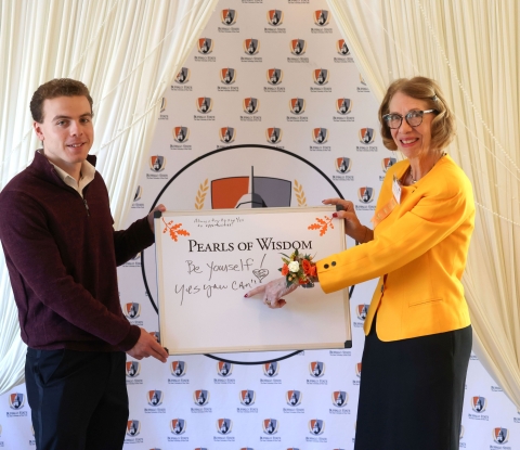 Matthew Barton and Michele M. Fairchild Marko with a dry erase board reading "Pearls of Wisdom"