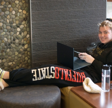 Smiling student sitting in the Fireside Lounge