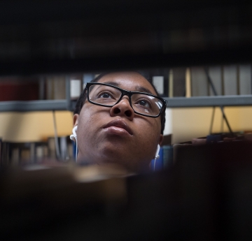 Student between racks of book in Butler Library
