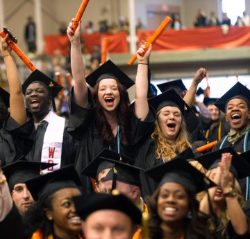 Joyful grads waving their diplomas