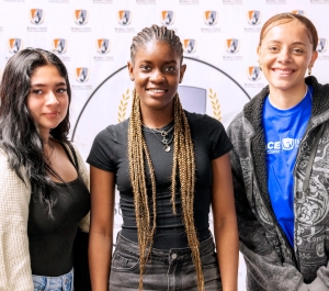 Three students in front of a Buffalo State backdrop