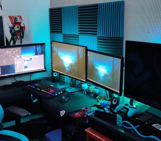 Gaming station with four screens on a desk with chair