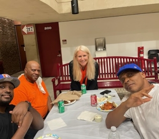 Vice President for Finance and Management Laura J. Barnum joins Buffalo State University staff at a table during the annual Second and Third Shift Pizza Party.