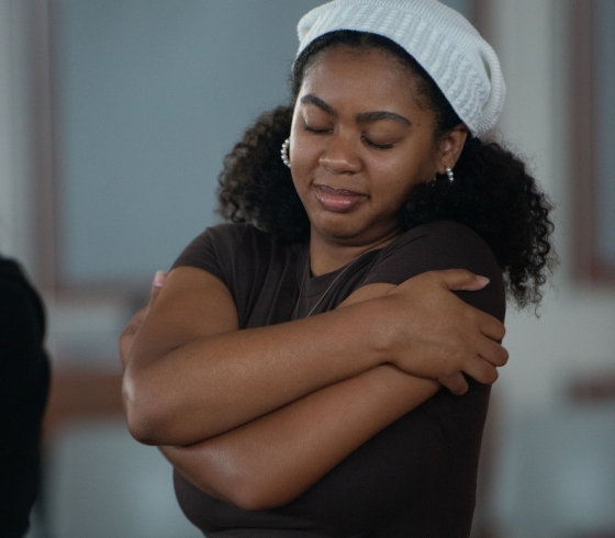 Female student giving herself a hug during a festival workshop