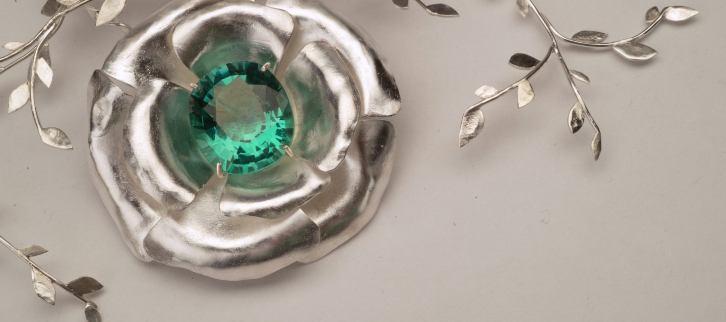 Silver jewelry piece with green stone