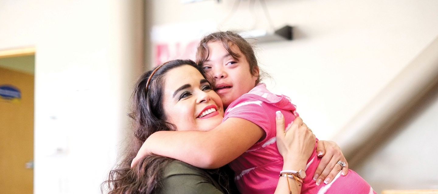 Student with down's syndrome hugs special education teacher