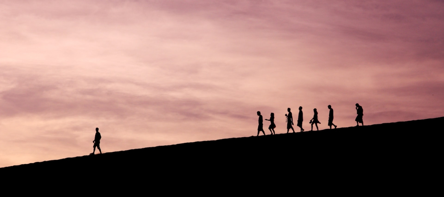 Silhouettes of a group following a leader