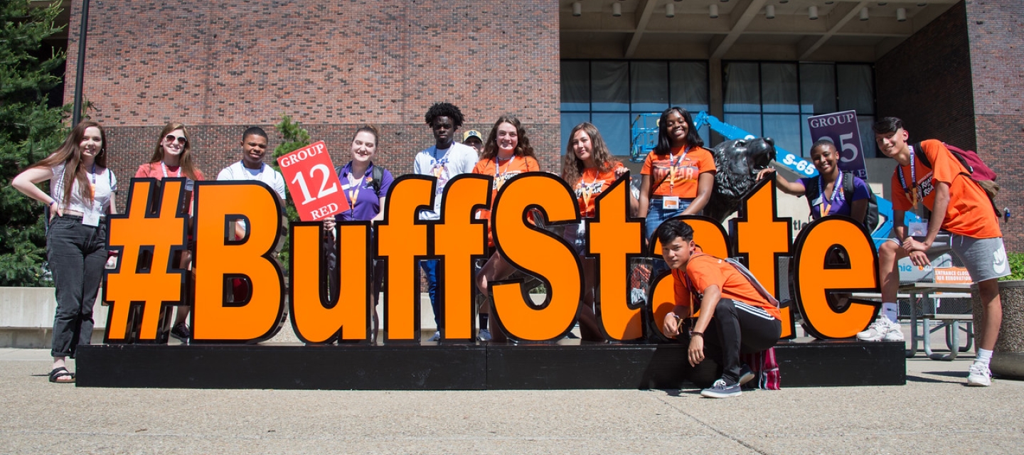 Group of students at Orientation posing behind the #BuffState sign in the plaza