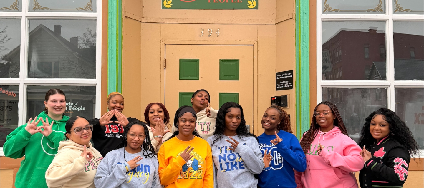 A group of female students outside a building with a sign reading Friends of Night People