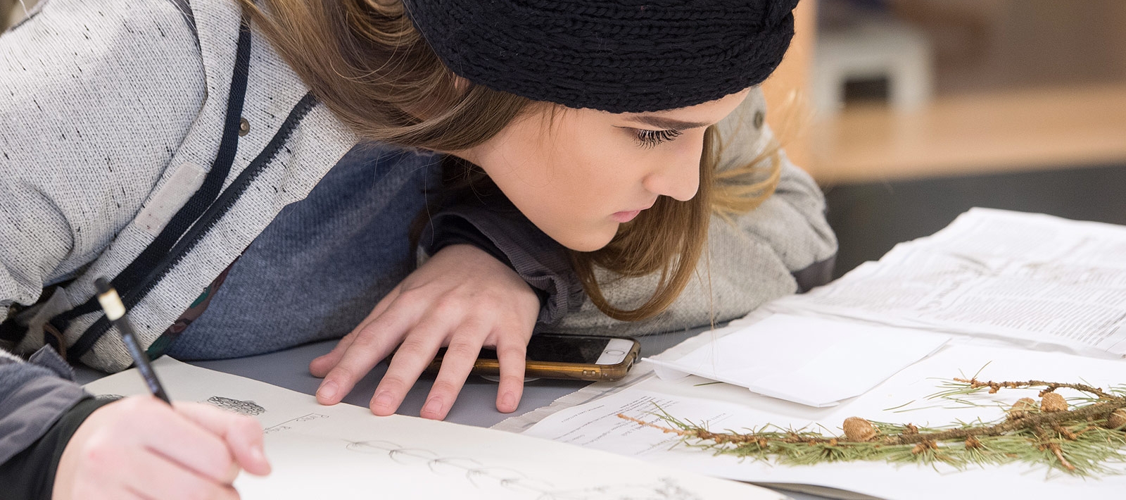 Graphic design student drawing in class