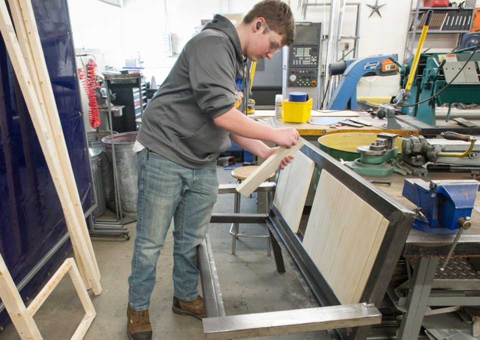 Student working on a metal bench