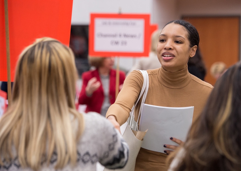 A female student shakes an interiewer's hand at the 2017 Buffalo State Job Fair