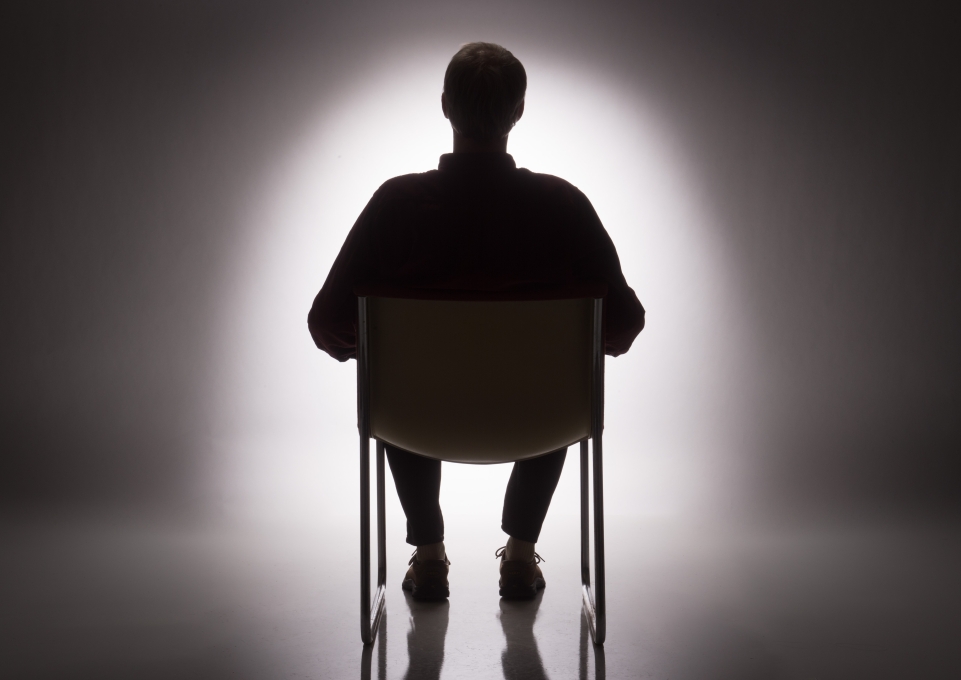 Silhouette of a man sitting in a chair