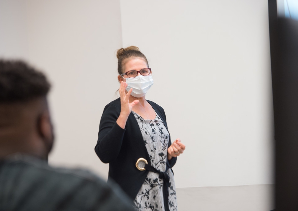 Martha Skerrett, wearing a face mask, lecturing in a graduate level class in fall 2020