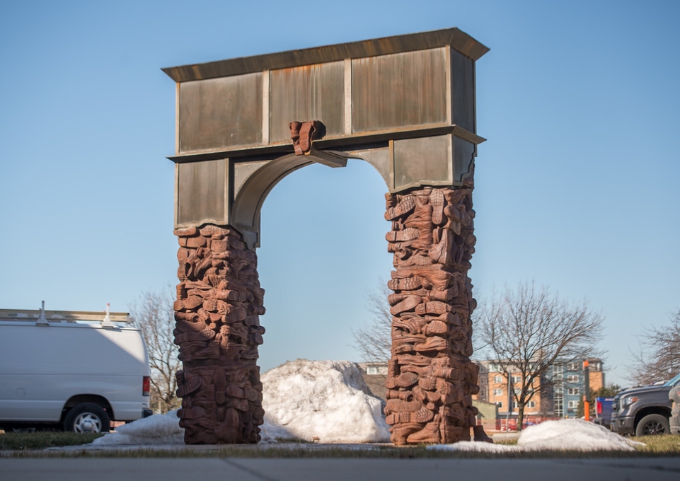 Photo of arch scuplture made of iron-cast workboots