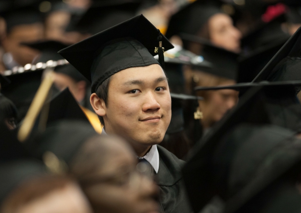 Student wearing mortarboard smiles at the camera