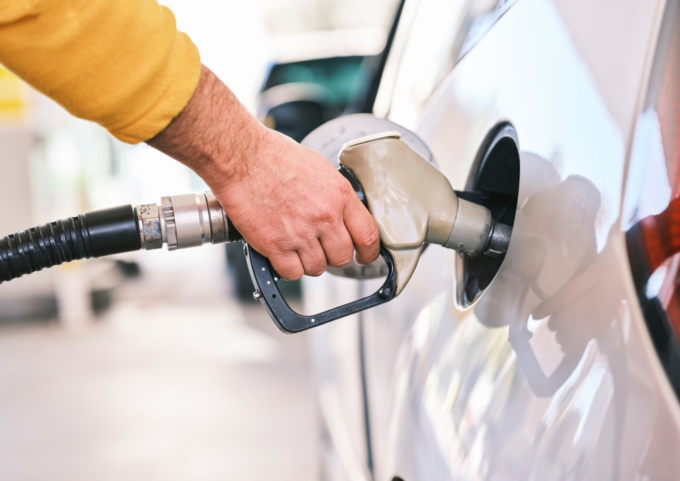 person pumping gasoline into an automobile