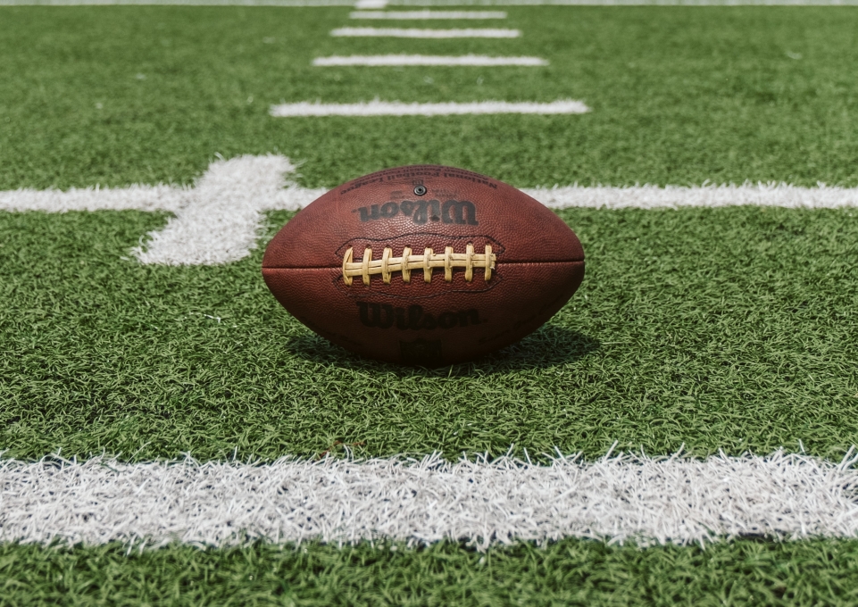 Closeup of a Wilson football placed on a football field