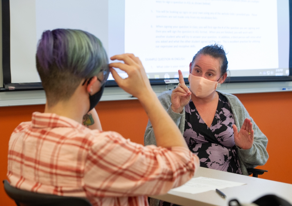 professor teaching a student American Sign Language