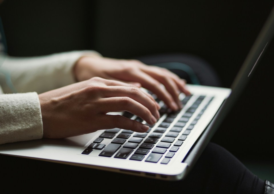 Hands typing on a laptop