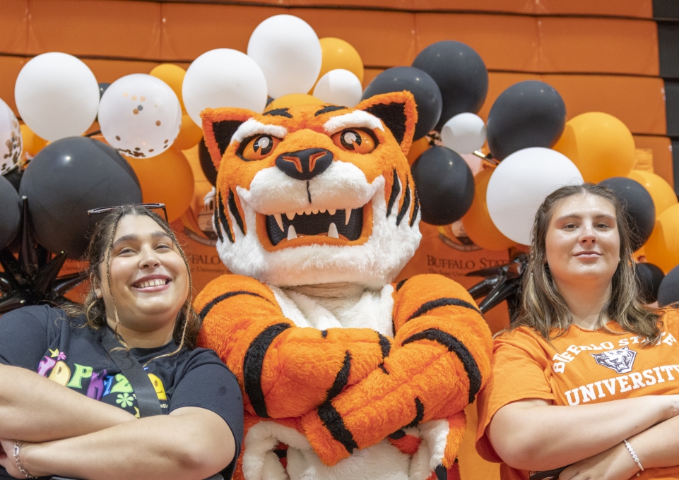 Two female students pose with Benji the Bengal mascot