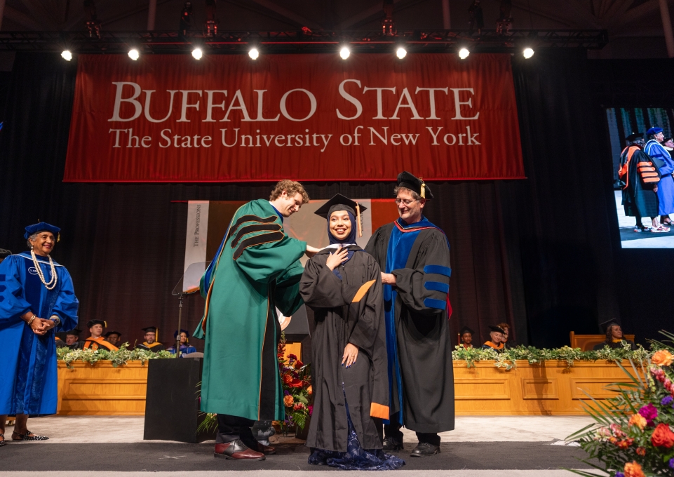 Student is presented by 2 professors at commencement