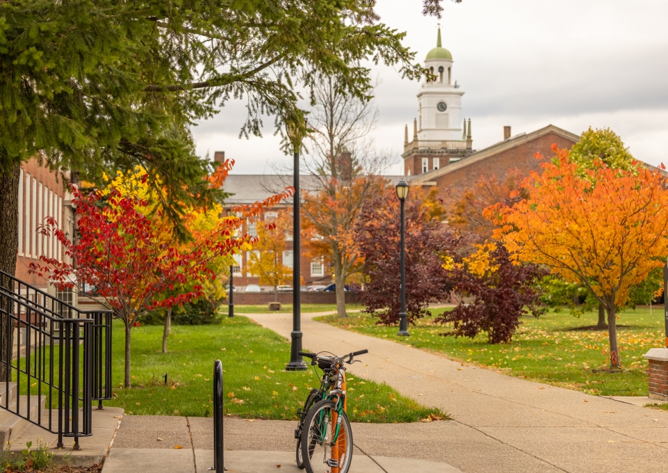 A bike on campus with fall foliage, Rockwell Hall visible