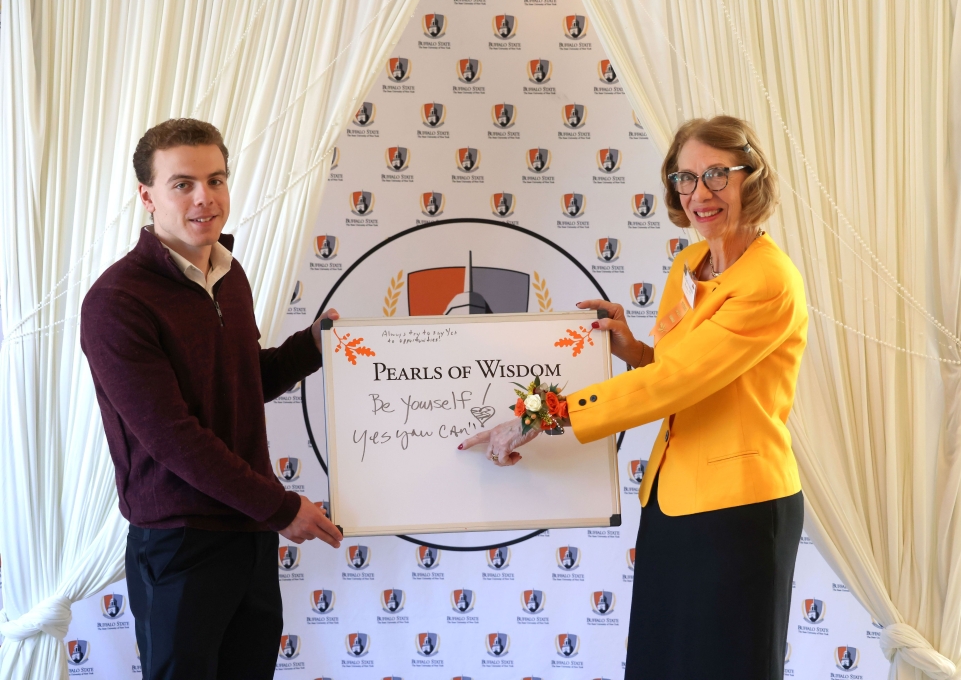 Matthew Barton and Michele M. Fairchild Marko with a dry erase board reading "Pearls of Wisdom"